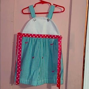 A blue romper with pink whales